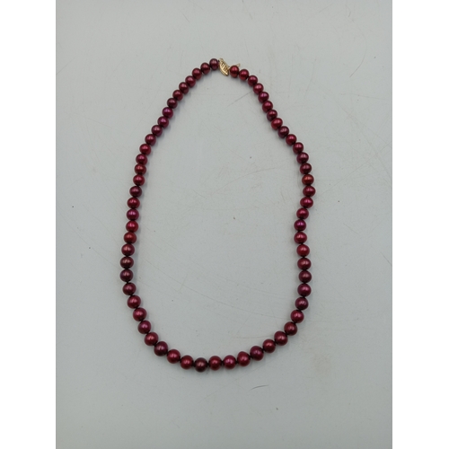 325 - An unusual red pearl necklace with clasp marked 14K, 45cm long