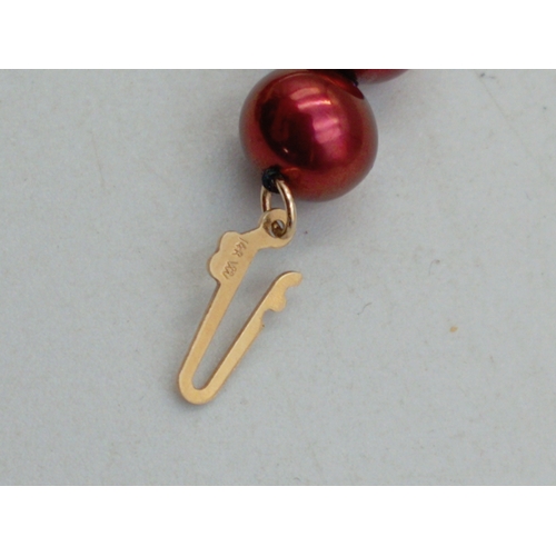 325 - An unusual red pearl necklace with clasp marked 14K, 45cm long