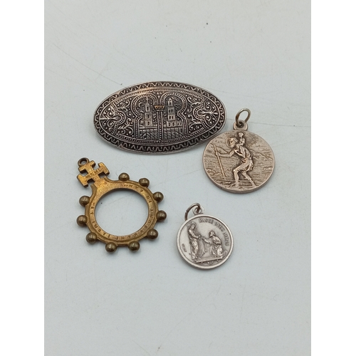 338 - An antique brass rosary ring together with a middle Eastern silver tone brooch, a St. Christopher pe... 