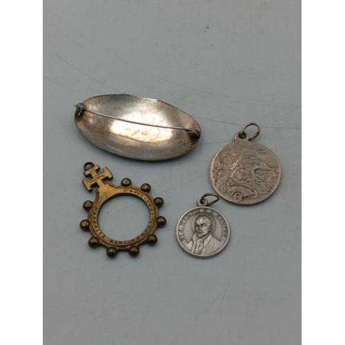 338 - An antique brass rosary ring together with a middle Eastern silver tone brooch, a St. Christopher pe... 