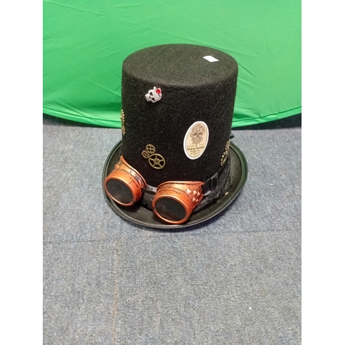2 - A black felt steampunk top hat with removable copper toned goggles, decorative cogs, and a skull bro... 