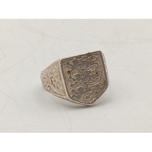 299 - A silver signet ring with Three Lions shield design, stamped SILVER