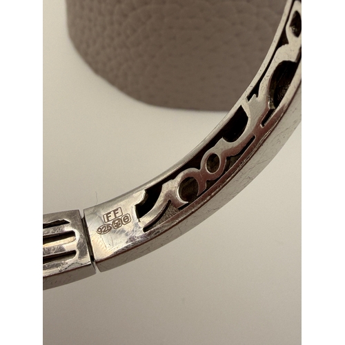 64 - A stamped 925 bangle featuring black and gold enamel circles design.