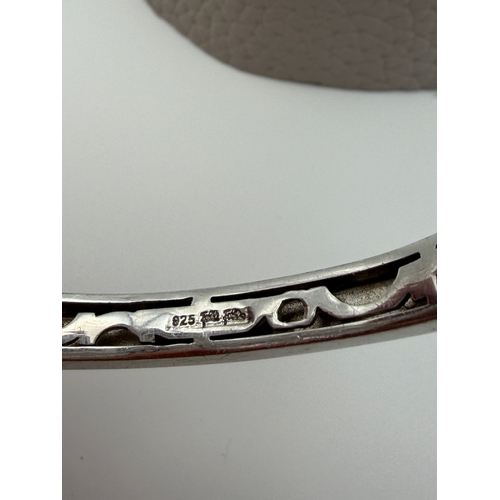 64 - A stamped 925 bangle featuring black and gold enamel circles design.
