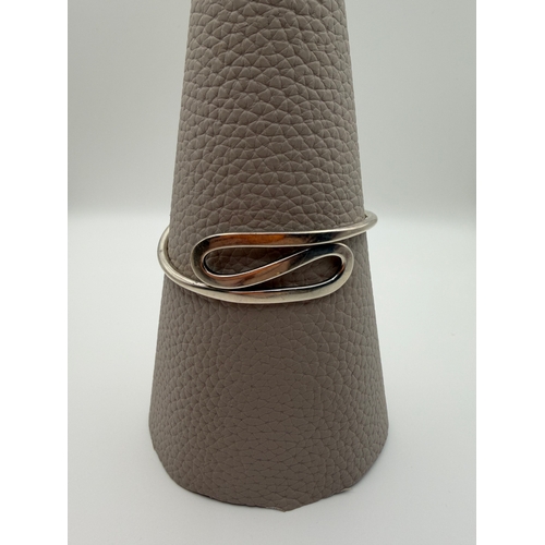 65 - A stamped 925 silver bangle in a modern style.