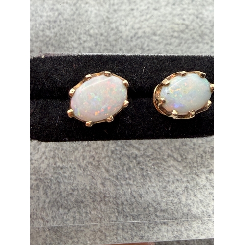 67 - A pair of hallmarked 375 9ct gold and opal studs with rare red colour.