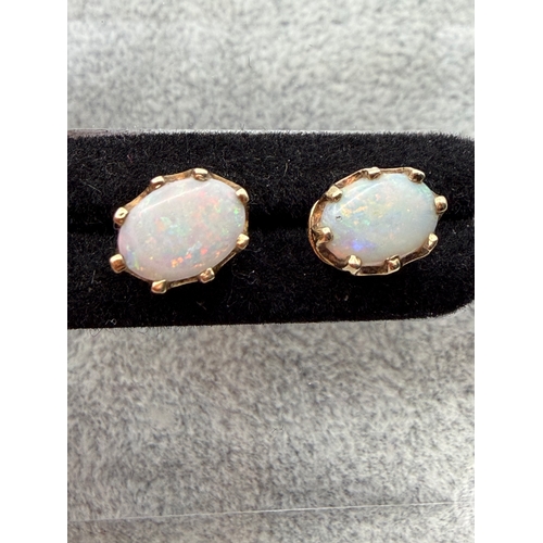 67 - A pair of hallmarked 375 9ct gold and opal studs with rare red colour.