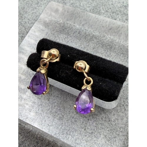 68 - A pair of tested 9ct gold and amethyst drop earrings.