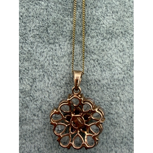 79 - A 9ct gold pendant with a floral design in light and dark pink stones on a silver necklace. Length 1... 