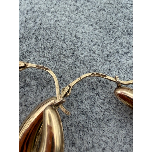 81 - A pair of 9ct Claddagh hoop earrings.