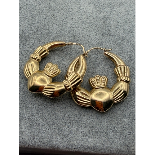 81 - A pair of 9ct Claddagh hoop earrings.