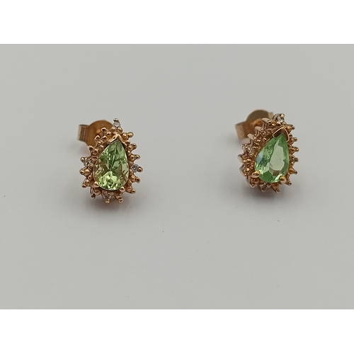 102 - A pair of stamped 375 9ct gold earrings set with Kenyan tsavorite and diamonds.