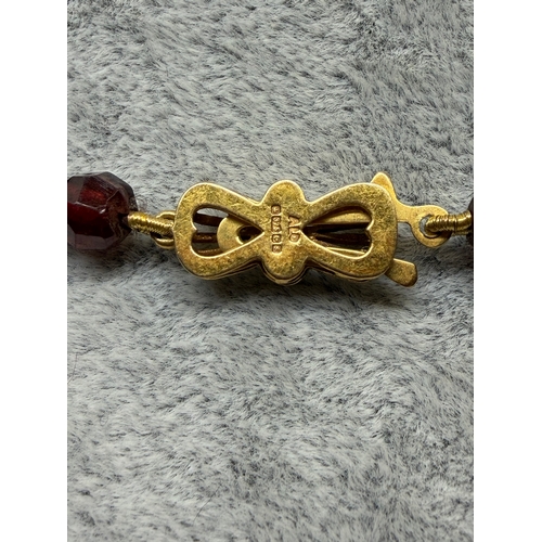 160 - An antique faceted garnet necklace featuring a 9ct gold clasp. Length 43.5 inches.