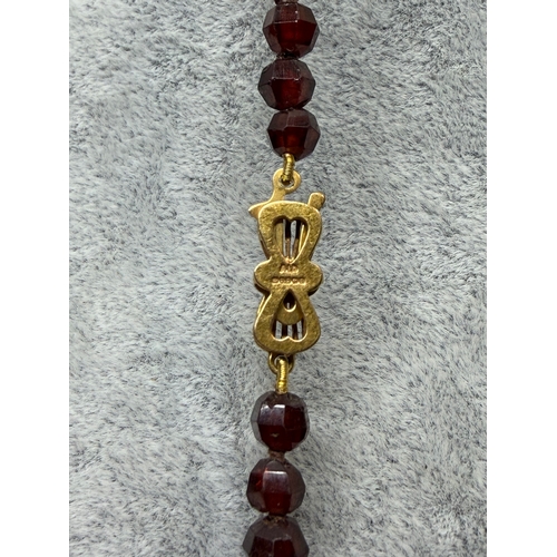 160 - An antique faceted garnet necklace featuring a 9ct gold clasp. Length 43.5 inches.