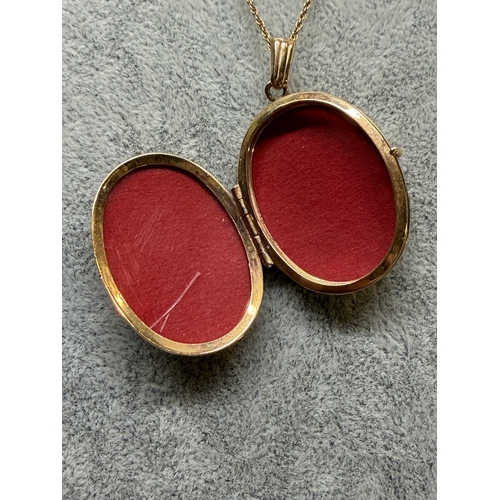 165 - A 9ct gold locket with a engraved floral pattern and an M monogram, fully hallmarked. Length 18 inch... 