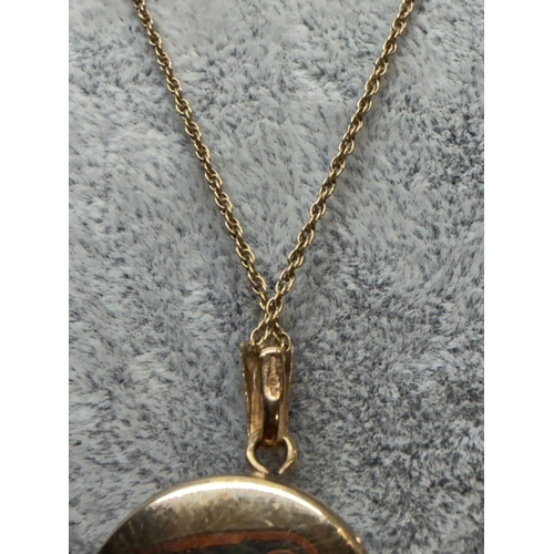 165 - A 9ct gold locket with a engraved floral pattern and an M monogram, fully hallmarked. Length 18 inch... 