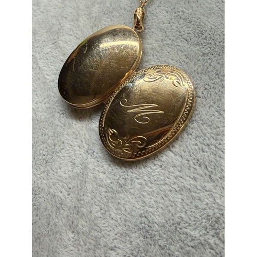 165 - A 9ct gold locket with a engraved floral pattern and an M monogram, fully hallmarked. Length 18 inch... 