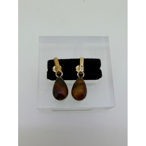 166 - A pair of Gold dangle earrings With pear shaped interchangeable stones. Amber on one side and Larima... 