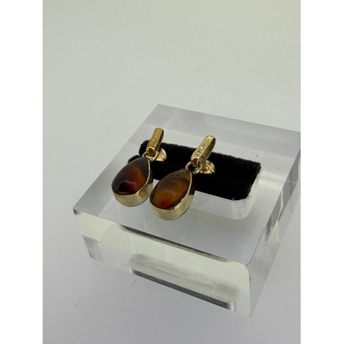 166 - A pair of Gold dangle earrings With pear shaped interchangeable stones. Amber on one side and Larima... 