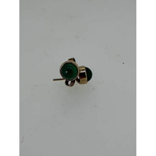 219 - A pair of 9ct yellow gold studs set with green onyx.