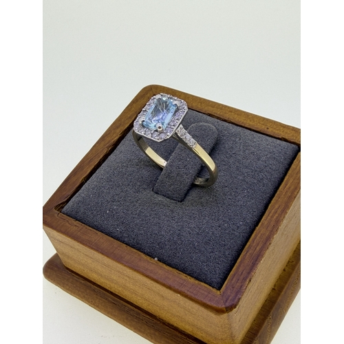 222 - A 9ct yellow gold ring with a cushion cut aquamarine surrounded by a halo of diamonds. Size Q and 1/... 