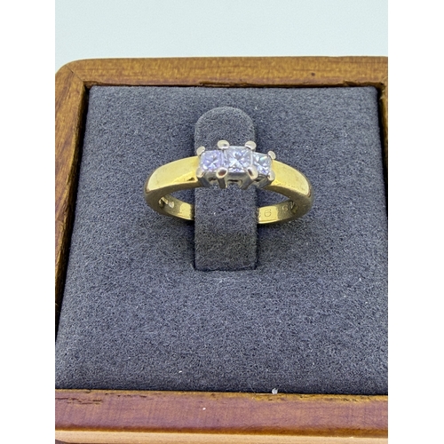 226 - A 18ct yellow gold engagement ring, set with a trio of emerald cut diamonds size J and 1/2. Weight 4... 