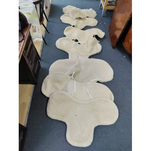 66 - A collection of 7 sheepskin wool saddle pads.