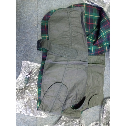 92 - A collection of 20  Barbour style waxed dog jackets. In various sizes.