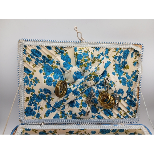 22 - A woven basket full of an assortment of sewing materials and accessories including scissors, needles... 