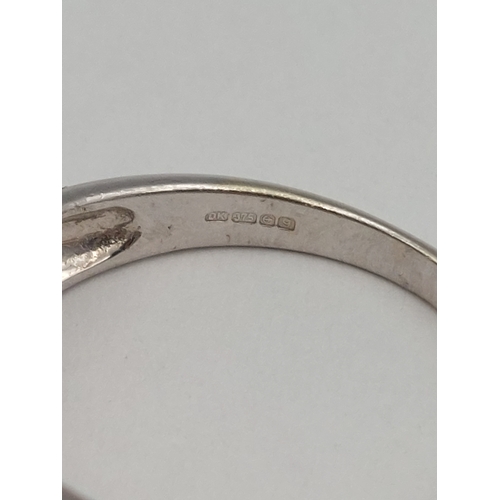 397 - A hallmarked 375 9ct white gold wide band ring set with white stones. Size N. Total weight 5.3g
