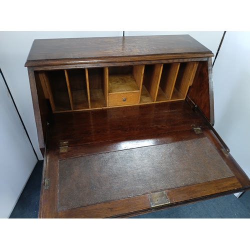 146 - An antique solid oak writing bureau, with fall front writing surface and 2 drawers. Height 40.5inche... 
