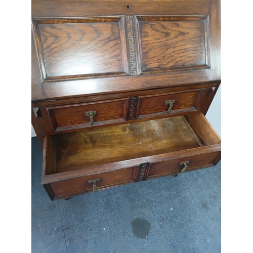 146 - An antique solid oak writing bureau, with fall front writing surface and 2 drawers. Height 40.5inche... 