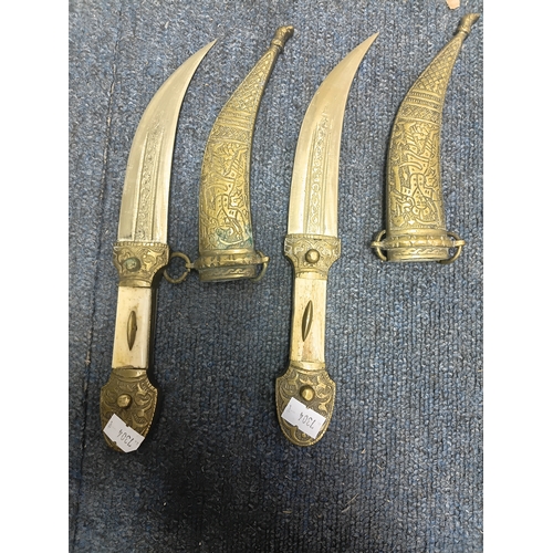 200 - A pair of middle Eastern brass and bone daggers with brass sheaths. Length 9.5 inches.