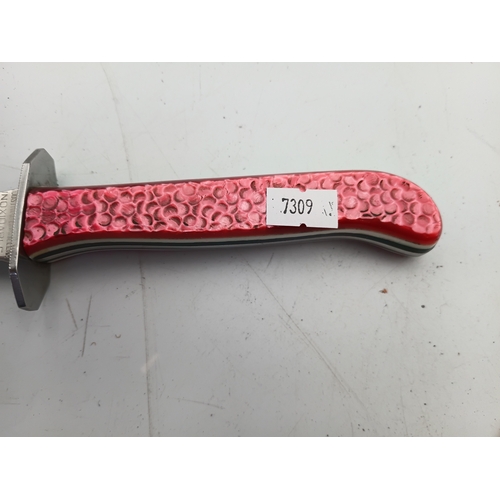 202 - A hunting knife with a 5inch stainless steel blade and a decorative pink handle with leather sheath.