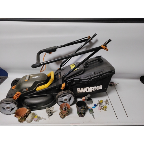 73 - A collection of garden items to include a WORX Cordless lawnmower working, plant pots, stakes and mo... 
