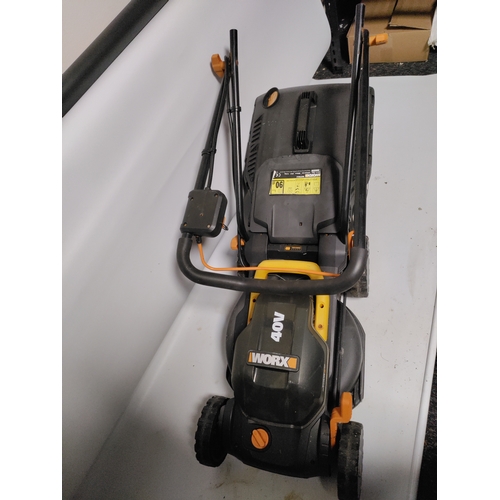 73 - A collection of garden items to include a WORX Cordless lawnmower working, plant pots, stakes and mo... 