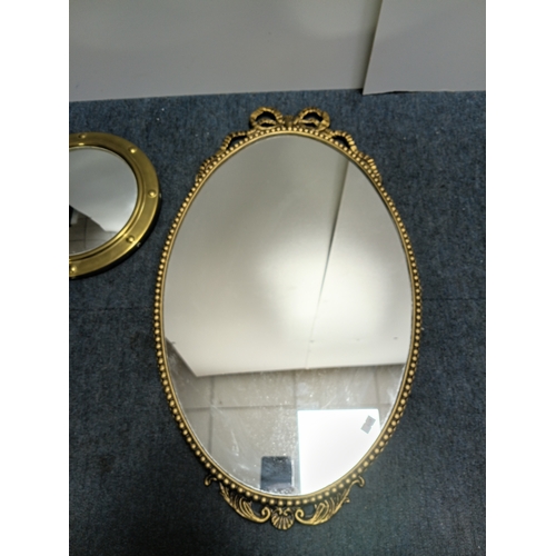 106 - A set of 3 gold gilt mirrors: a small brass port hole style mirror and 2 metal mirrors. The largest ... 