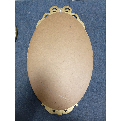 106 - A set of 3 gold gilt mirrors: a small brass port hole style mirror and 2 metal mirrors. The largest ... 