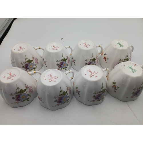 276 - A Royal Crown Derby Tea set. To include, 8 teacups, 1 teapot, 1 milk jug, 1 sandwich plate, 3 plates... 