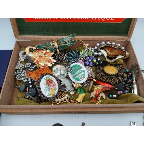 222 - A collection of jewellery in a Corps Diplomatique cigar box. Jewellery includes, watches, brooches, ... 