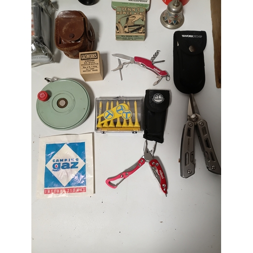 86 - A collection of odds to include, pocket multi tools , tees, plasters, a bell and more.
