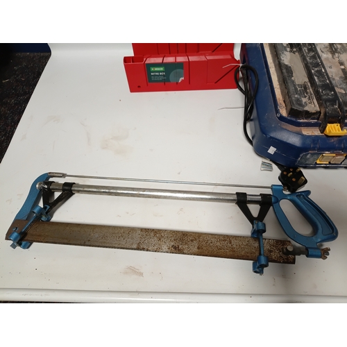 87 - A MacAllister tile cutting machine pat tested and working, plus a saw, a mitre box, and a saw clamp.