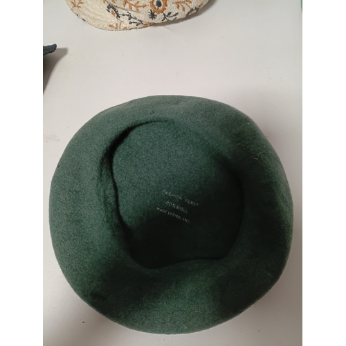 282 - A collection of 4 hats, to include, a white embroidered cap featuring a floral pattern,  a green fel... 