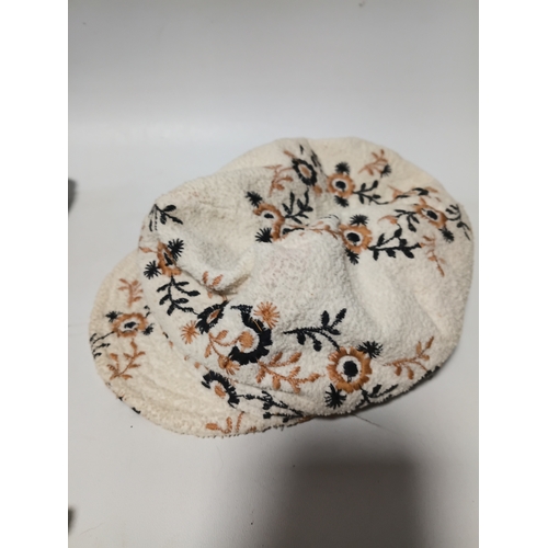282 - A collection of 4 hats, to include, a white embroidered cap featuring a floral pattern,  a green fel... 