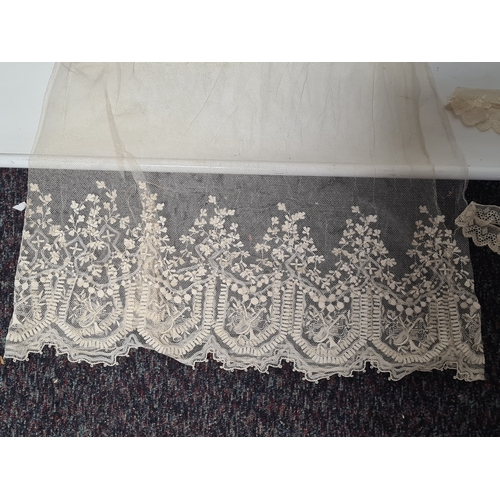 241 - A collection of vintage lace items to include a netted dress (in parts), a white tablecloth which me... 
