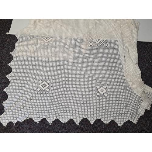241 - A collection of vintage lace items to include a netted dress (in parts), a white tablecloth which me... 
