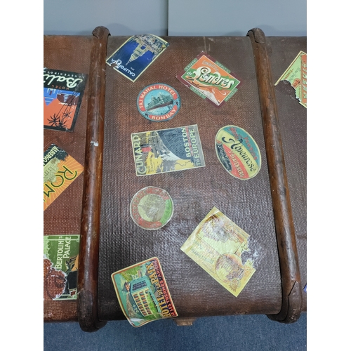 302 - A collectable vintage steamer trunk featuring various travel stickers from destinations like Rome an... 