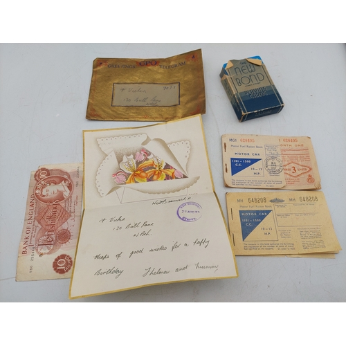 219 - A late 1930s Greetings telegram with 10 shilling note, together with two motor fuel ration books and... 