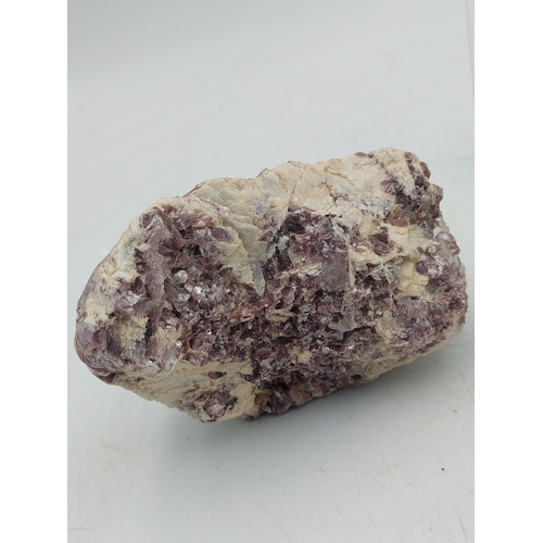 261 - A lepidolite crystal with display case. Measures 4 inches x 2 inches. Weight 515 grams.