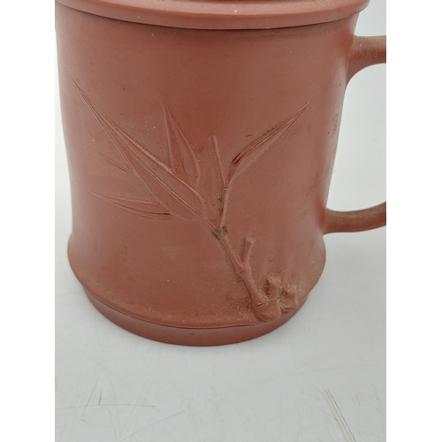 273 - A Chinese Yixing Zisha clay lidded tea mug featuring bamboo-themed decorations.